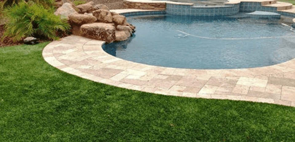 artificial grass garden with stone pool border